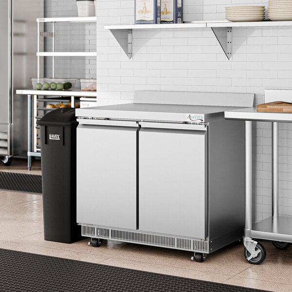 An Avantco front breathing worktop freezer in a commercial kitchen with a stainless steel counter.