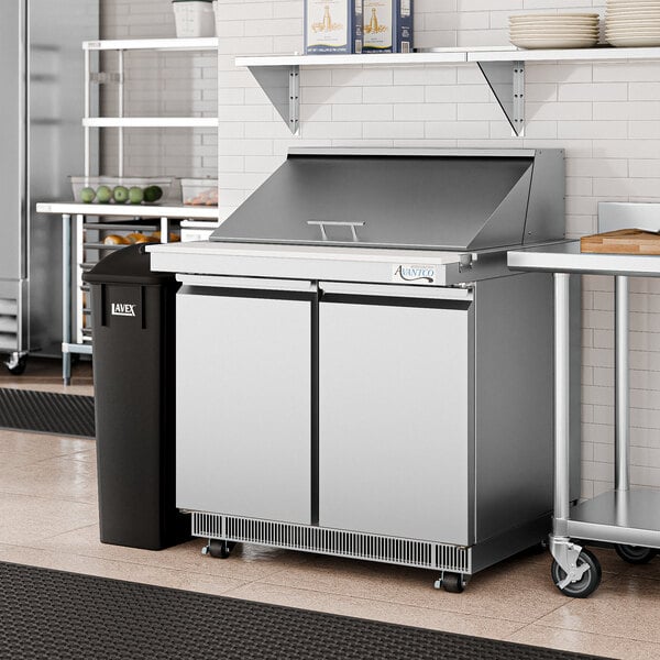 An Avantco 36" mega top sandwich prep table with a stainless steel lid on a counter.