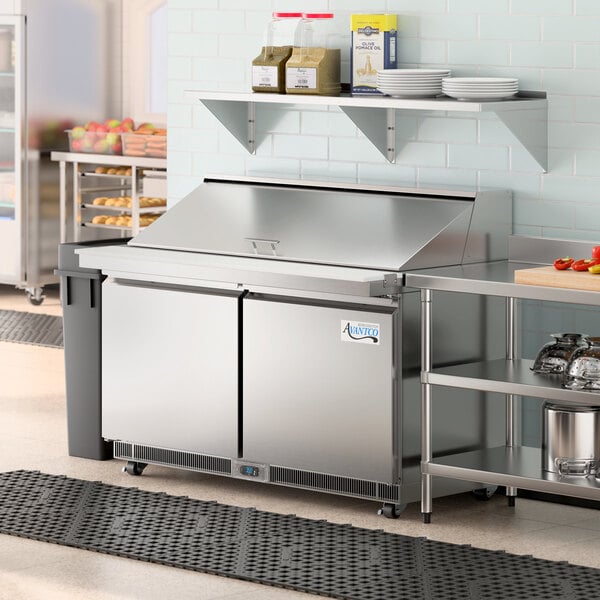 An Avantco stainless steel 2 door front breathing mega top refrigerated sandwich prep table on a counter in a commercial kitchen.