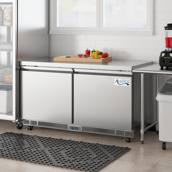 An Avantco stainless steel undercounter refrigerator on a counter with a door open.