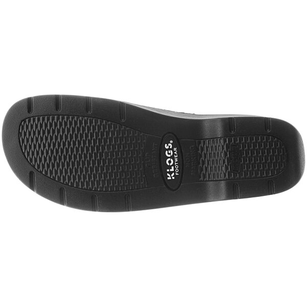 The brown sole of a Klogs clog with a floral pattern.