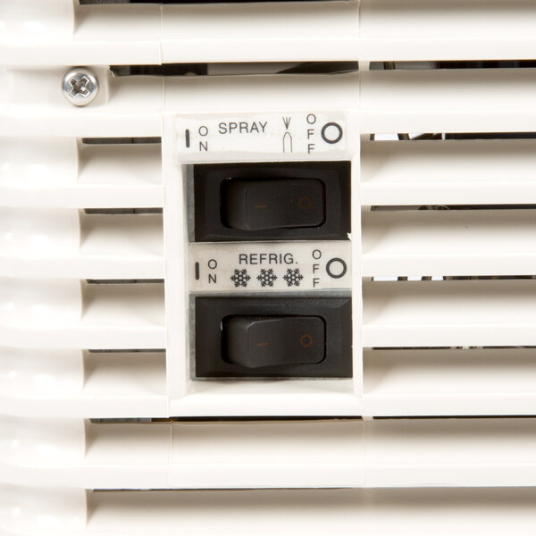 A close up of a white Crathco Mini-Twin beverage dispenser with a switch with red and orange text.