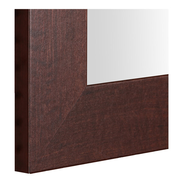 A close-up of a BrandtWorks dark walnut wood mirror frame.