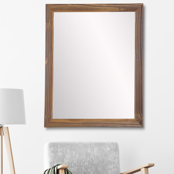 A BrandtWorks natural wood tone mirror on a wall.