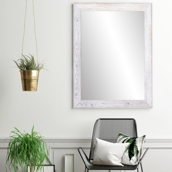 A BrandtWorks white farmhouse mirror hanging on a wall.