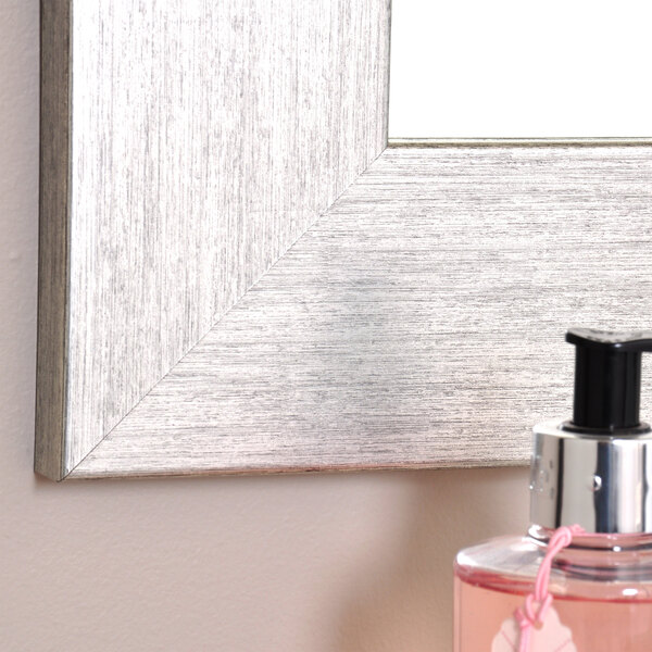 A BrandtWorks silver grain finish mirror above a liquid soap bottle.