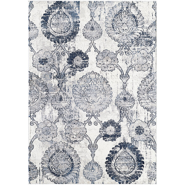 A close-up of a cream rug with a circular blue and white medallion pattern.