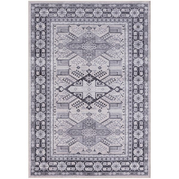 A close up of a gray and cream Abani Molana Collection area rug with a pattern of gray and black designs.