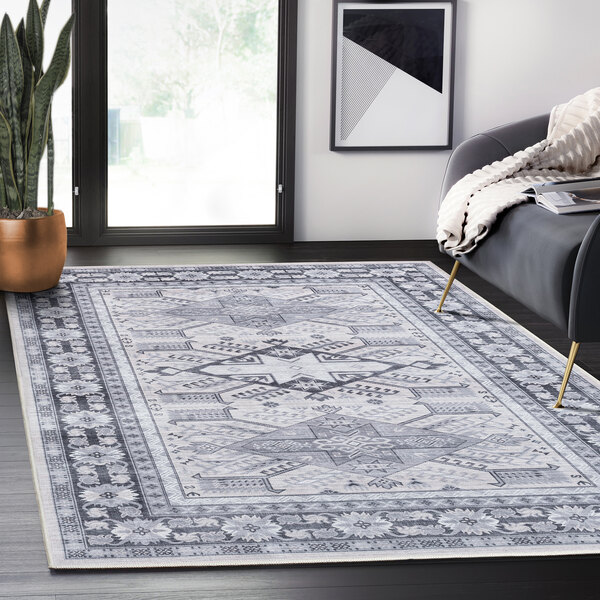An Abani Molana Collection gray and cream vintage folk area rug with a gray and white design on a floor.