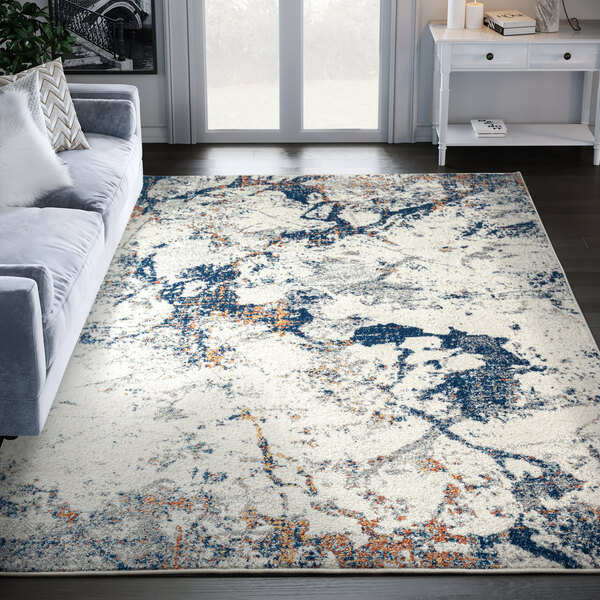 An Abani Casa Collection gray area rug with blue and white abstract designs in a room.