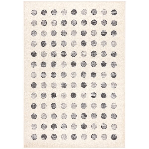 A cream area rug with gray and black geometric dots.