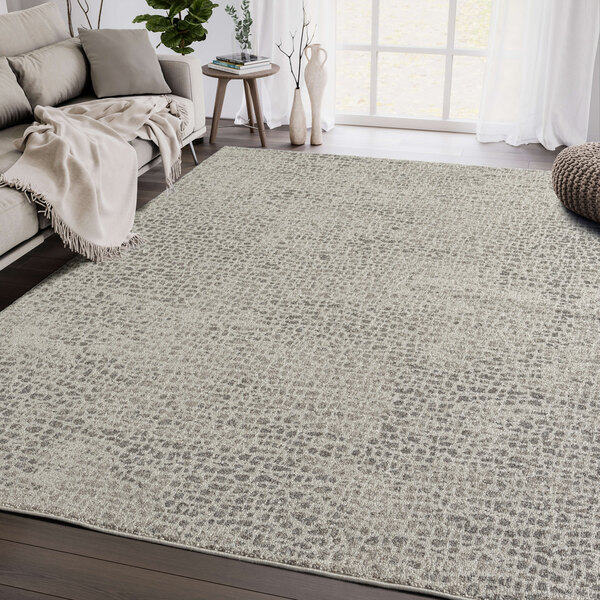 An Abani Layla Collection beige and brown distressed animal print area rug in a room with a couch and blanket.