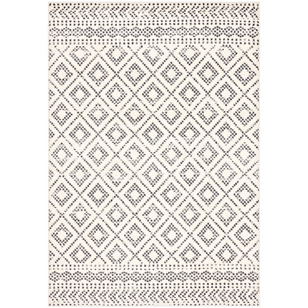 A close up of a cream and gray Moroccan area rug with a geometric pattern.