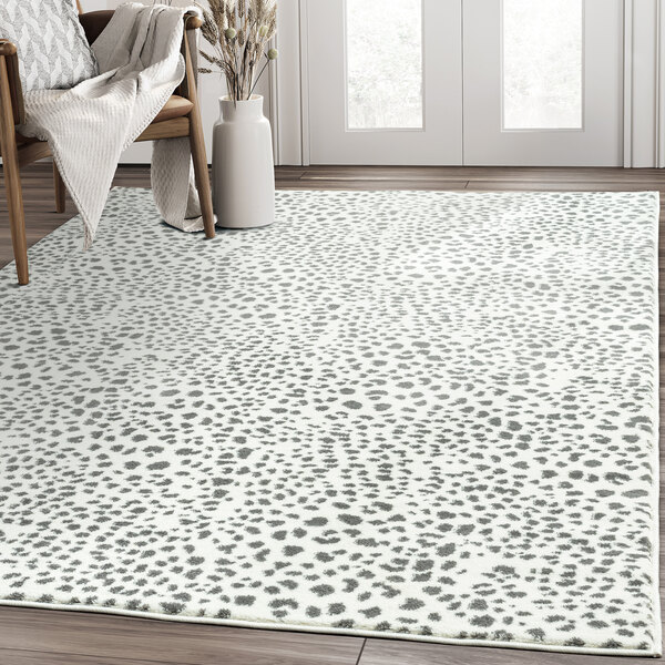 An Abani Arto cream and grey area rug with a cheetah print in a white room.
