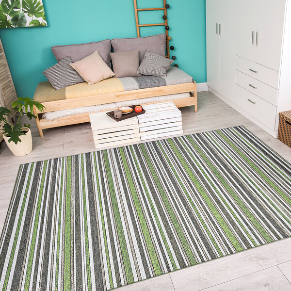 A Couristan Cape Brockton hunter green and brown striped area rug on a wood floor in a white room with a bed.
