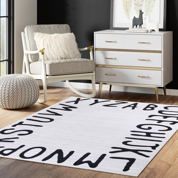 A cream rug with black letters that spell out 'NY' in a white room.