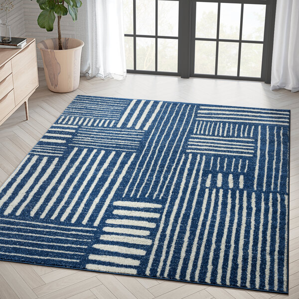 An Abani Casa Collection navy blue and white Southwestern geometric area rug in a room.