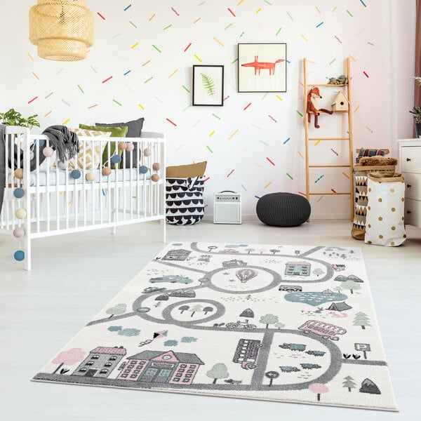 A white crib in a room with a colorful garden town rug.