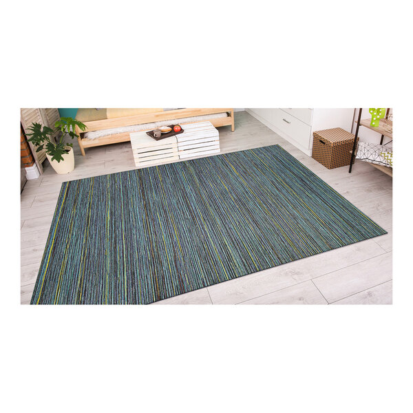 A Couristan teal and cobalt area rug with blue stripes on the floor.