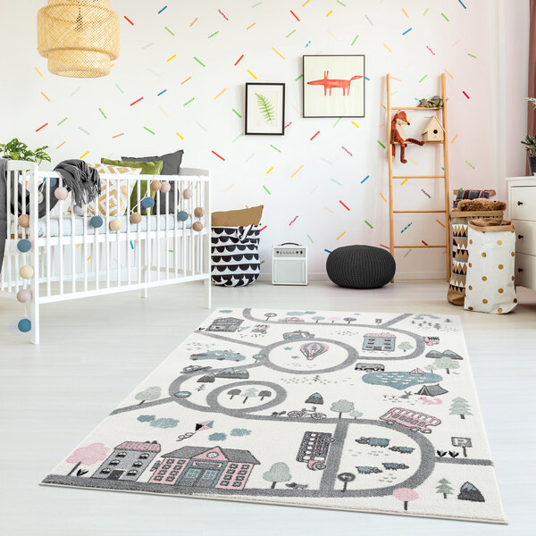 A white crib in a room with a colorful rug.