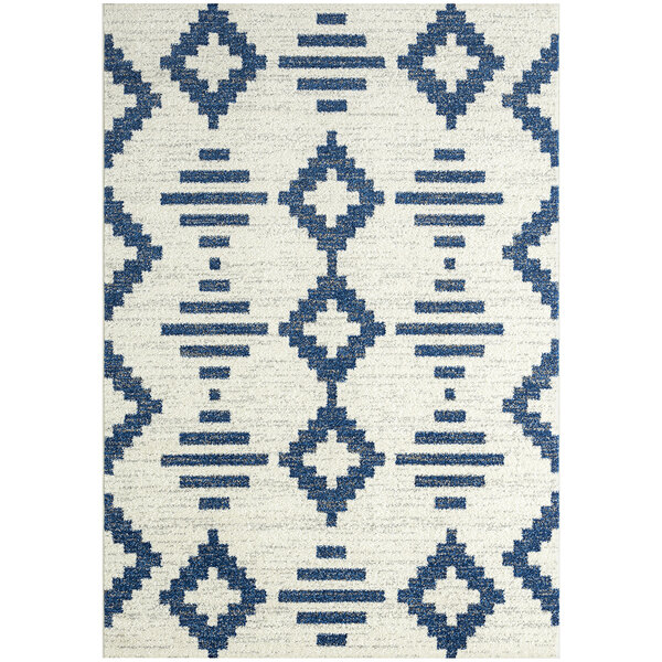 A close up of an Abani Casa Collection navy and cream area rug with a geometric design in a room with white walls.