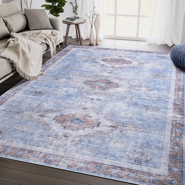 An Abani Molana Collection beige and blue area rug with a vintage medallion design.