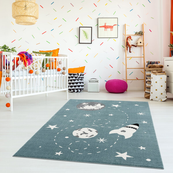 A white baby's room with a white crib and a blue rug with white circles.