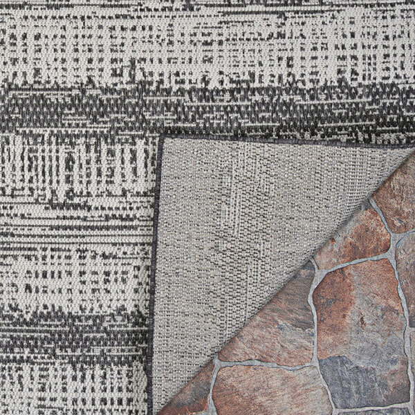 A close up of a Couristan Tangent area rug with a stone pattern in charcoal and ivory.