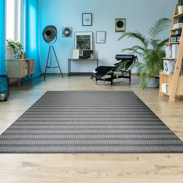 A Couristan Afuera Beachcomber area rug in a room with wood floors.