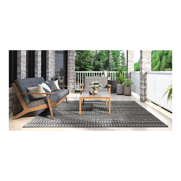 A table and chairs on a Couristan Bristol area rug on a patio.