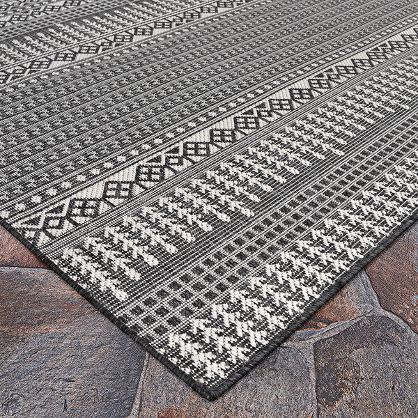 A Couristan area rug with a black and white geometric design.