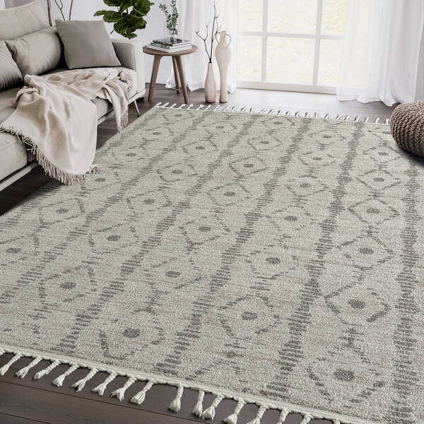 A beige and brown Abani Layla Collection area rug with a diamond pattern and fringes.