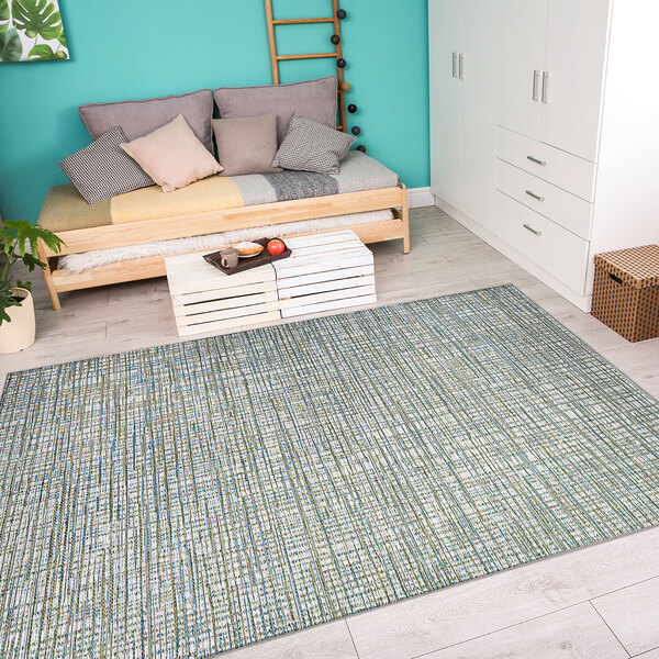A white bedroom with a Couristan ivory and hunter area rug.