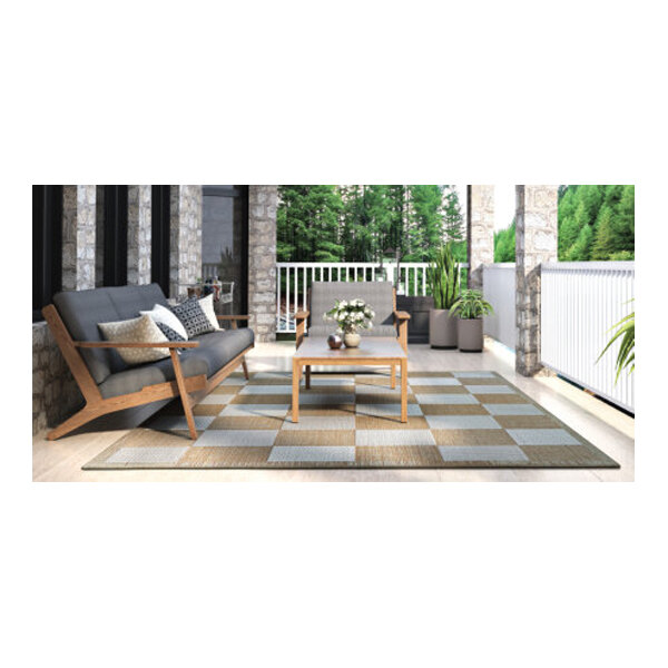 A Couristan checkered area rug under a table and chairs on a patio.