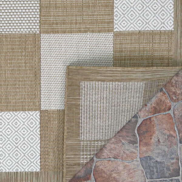 A close up of a Couristan light brown and ivory checkered point area rug.