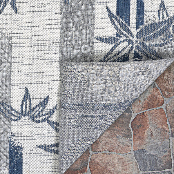 A Couristan area rug with a bamboo stripe pattern in blue and ivory.