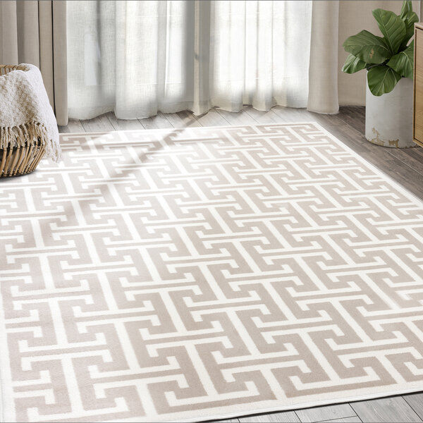 An Abani Arto Collection cream and beige area rug with a geometric pattern in a room.