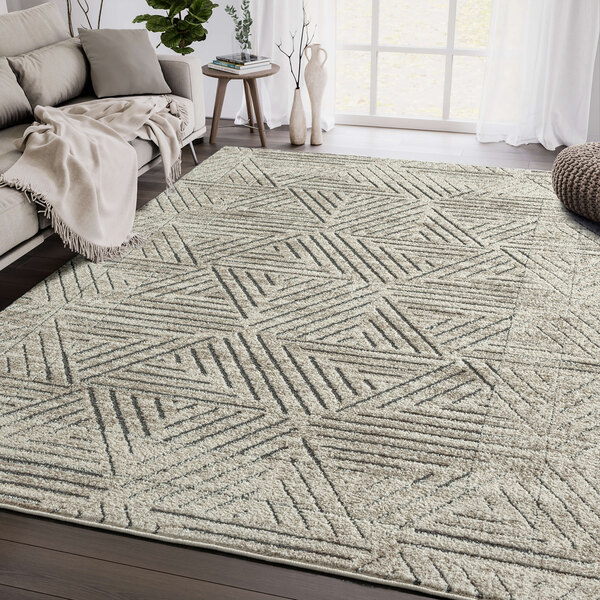An Abani Cabo Collection cream and gray geometric triangle area rug in a room.