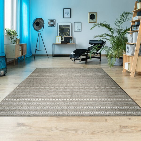 A Couristan Afuera Beachcomber area rug in a living room with a wood floor.