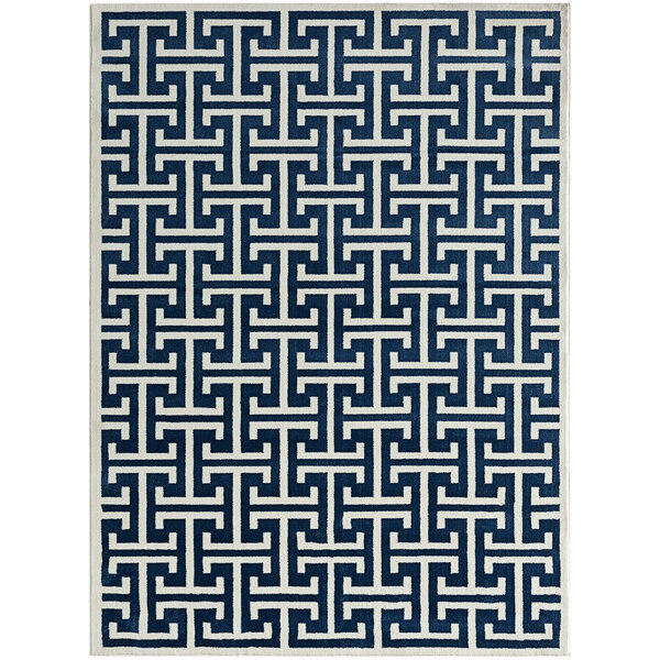 An Abani Arto cream and blue area rug with a geometric design in a white room.