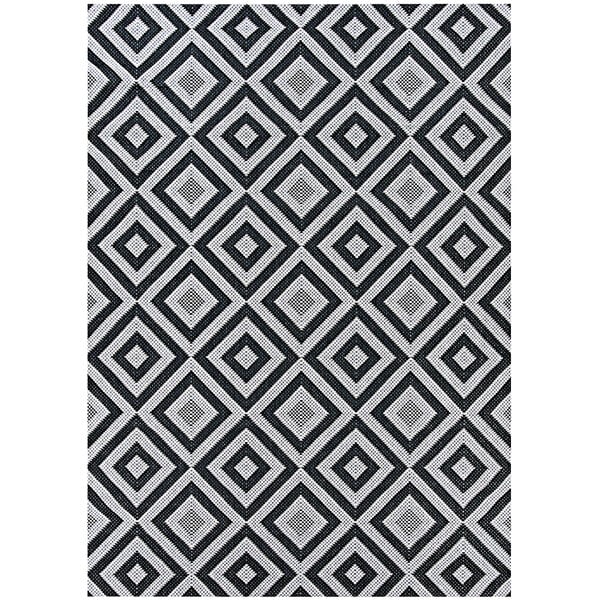 A close up of a Couristan Afuera Dipole black and white diamond pattern area rug.