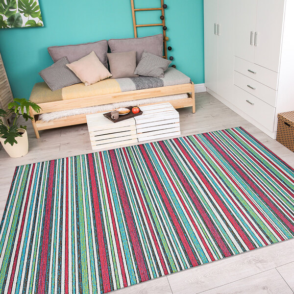 A Couristan Cape Brockton purple multi-colored striped rug in a room with a white bench, couch, and tray of food.