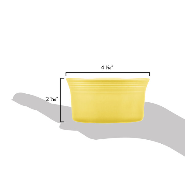 A yellow Fiesta ramekin with measurements on it.
