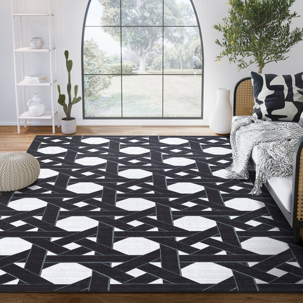 An Abani Parker Collection cream and black geometric houndstooth area rug with a geometric design in a room with a couch and a window.
