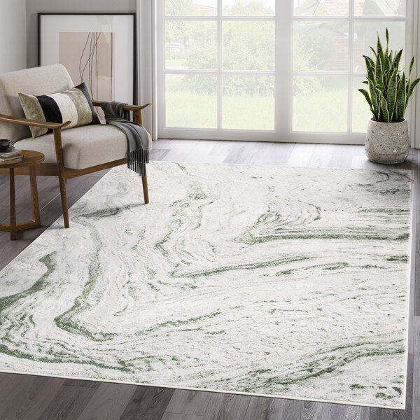 A green and gray Abani Atlas Collection area rug with a contemporary abstract marble pattern in a room with a wooden chair and a plant.