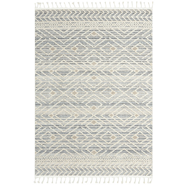 An Abani Cabo Collection beige and gray area rug with a diamond pattern and fringes.