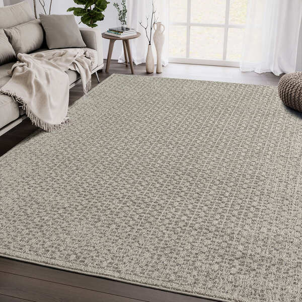 An Abani Layla Collection beige and brown distressed area rug with a gray and white pattern in a room.