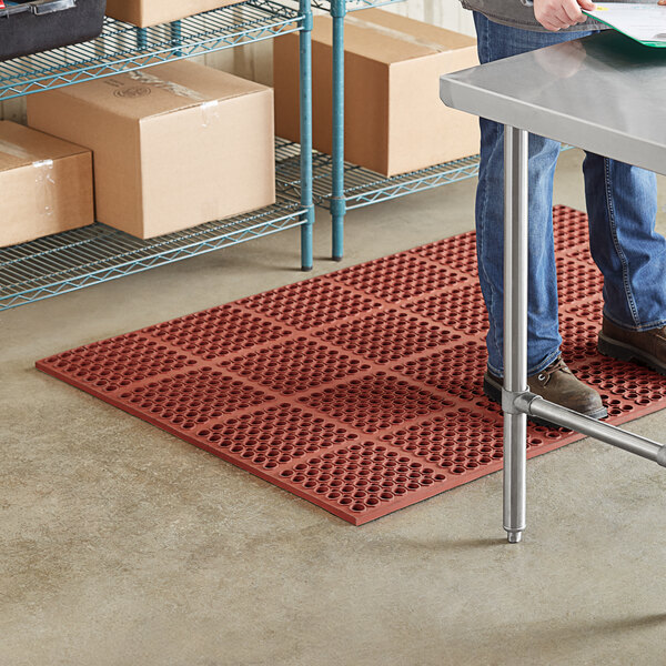 A man standing on a red Lavex anti-fatigue floor mat.
