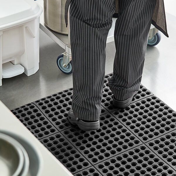 A person standing on a black Lavex anti-fatigue floor mat.