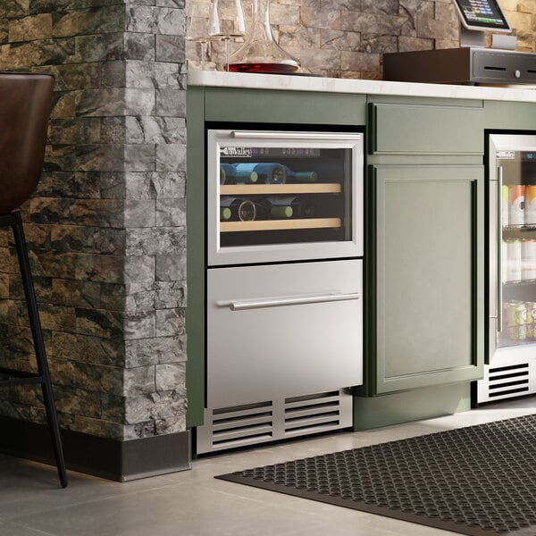 A dual temperature beverage cooler with a glass door top section for bottles and a stainless steel bottom drawer, built into a kitchen counter.